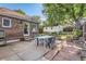 Exterior backyard view features a brick home, concrete patio, lawn, garden, and a white detached garage at 1006 S Emerson St, Denver, CO 80209