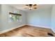 A bedroom features a ceiling fan and hardwood floors with a large window that offers natural light at 1006 S Emerson St, Denver, CO 80209