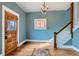 Elegant entryway featuring hardwood floors, chandelier, staircase, and a stunning wooden door at 1006 S Emerson St, Denver, CO 80209
