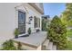 Inviting front porch with black wrought iron door, small table set, and manicured landscaping at 1006 S Emerson St, Denver, CO 80209