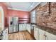 Well-appointed kitchen with brick accents, stainless steel appliances, and ample counter space at 1006 S Emerson St, Denver, CO 80209