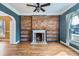 Inviting living room showcases a brick fireplace, hardwood floors, and natural light through a window at 1006 S Emerson St, Denver, CO 80209