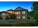 Twilight exterior showing the home's outdoor living space, patio, and lovely facade with stone and paneled accents at 10731 Featherwalk Ln, Highlands Ranch, CO 80126