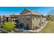 Beautiful back exterior with stone accents, a cozy patio, and a staircase leading to an upper deck at 10731 Featherwalk Ln, Highlands Ranch, CO 80126
