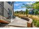 Backyard patio with outdoor seating and a curved stone retaining wall in a landscaped yard at 10731 Featherwalk Ln, Highlands Ranch, CO 80126