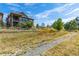 Expansive backyard featuring a well-maintained lawn, mature trees, and white picket fencing around the property at 10731 Featherwalk Ln, Highlands Ranch, CO 80126