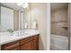 Bathroom showcasing wood cabinetry, a white countertop, and a tiled shower at 10731 Featherwalk Ln, Highlands Ranch, CO 80126