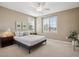 Bright bedroom featuring neutral decor, a ceiling fan, and a large window at 10731 Featherwalk Ln, Highlands Ranch, CO 80126