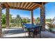 Covered patio with stone pillars, outdoor dining furniture, and views of the landscaped backyard at 10731 Featherwalk Ln, Highlands Ranch, CO 80126