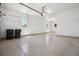 Spacious garage with speckled flooring, two windows, white walls, and an automated garage door opener at 10731 Featherwalk Ln, Highlands Ranch, CO 80126