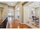 Hallway with wood floors and white trim, leading to other rooms including a study with glass doors at 10731 Featherwalk Ln, Highlands Ranch, CO 80126