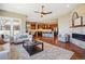 Open concept living room and kitchen with hardwood floors, fireplace, ceiling fan, and large windows at 10731 Featherwalk Ln, Highlands Ranch, CO 80126