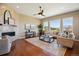 Bright living room with hardwood floors, a fireplace, and large windows offering natural light and views at 10731 Featherwalk Ln, Highlands Ranch, CO 80126