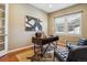 Bright office space with a modern desk, hardwood floors, and a large window with natural light at 10731 Featherwalk Ln, Highlands Ranch, CO 80126