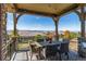 Covered patio with outdoor seating, stone pillars, string lights, and scenic mountain views at 10731 Featherwalk Ln, Highlands Ranch, CO 80126