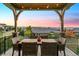 Outdoor patio with table and chairs overlooking mountain views at sunset at 10731 Featherwalk Ln, Highlands Ranch, CO 80126