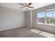 Bedroom featuring neutral carpet, light gray walls, natural light from a large window, and overhead ceiling fan at 12210 Pine Post Dr, Parker, CO 80138
