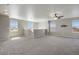 Spacious bonus room with neutral carpet, ceiling fan, and plenty of natural light from the large windows at 12210 Pine Post Dr, Parker, CO 80138