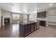 Open floor plan featuring a kitchen island, fireplace, and access to the patio at 12210 Pine Post Dr, Parker, CO 80138