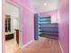 Unique bonus room featuring custom-built blue shelving and plush pink carpet at 309 Lincoln Ave, Platteville, CO 80651