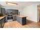 Well-lit kitchen featuring grey cabinets, butcher block countertops, and hardwood floors at 309 Lincoln Ave, Platteville, CO 80651