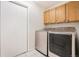 Bright laundry room with tile flooring, washer, dryer, and storage cabinets at 309 Lincoln Ave, Platteville, CO 80651