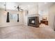Comfortable living room featuring a fireplace, a ceiling fan, and a connecting bathroom at 309 Lincoln Ave, Platteville, CO 80651