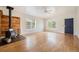 Bright living room with hardwood flooring and a wood-burning stove with a custom wood panel at 309 Lincoln Ave, Platteville, CO 80651