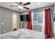 Bedroom features a ceiling fan, mounted TV, and en suite bath with updated vanity and glass shower at 1204 S Uvalda St, Aurora, CO 80012