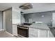 A cozy kitchen with stainless steel appliances, range hood and a grey and white backsplash at 1204 S Uvalda St, Aurora, CO 80012
