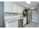 A lovely view of the kitchen with white cabinetry, stainless steel appliances, and washer/dryer at 1204 S Uvalda St, Aurora, CO 80012