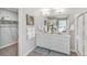 Bathroom featuring a double sink vanity with quartz countertop, a large mirror, and a glass shower at 4338 Cattle Cross Trl, Castle Rock, CO 80104