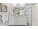 Bathroom featuring a double sink vanity with quartz countertop, large mirror, and glass shower at 4338 Cattle Cross Trl, Castle Rock, CO 80104