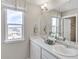 Bright bathroom featuring double sinks, a large mirror, and modern fixtures at 4338 Cattle Cross Trl, Castle Rock, CO 80104