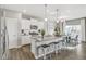 Bright kitchen and dining area featuring white cabinets, stainless steel appliances, and bar stool seating at 4338 Cattle Cross Trl, Castle Rock, CO 80104
