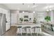 Bright kitchen and dining area featuring white cabinets, stainless steel appliances, and bar stool seating at 4338 Cattle Cross Trl, Castle Rock, CO 80104