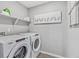 Practical laundry room with a Whirlpool washer and dryer set and modern shelving at 4338 Cattle Cross Trl, Castle Rock, CO 80104