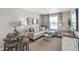 Bright living room featuring a gray couch with pillows, a side table, art, and a window with curtains at 4338 Cattle Cross Trl, Castle Rock, CO 80104