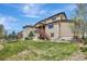 Large backyard showcasing green grass, mature trees, and a deck with stairs leading to the yard at 22268 E Hidden Trail Dr, Parker, CO 80138