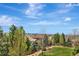 Scenic backyard view from the deck, showcasing a well-maintained lawn, trees, and distant mountain views at 22268 E Hidden Trail Dr, Parker, CO 80138