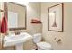 Powder room with pedestal sink, framed mirror, and toilet at 22268 E Hidden Trail Dr, Parker, CO 80138