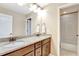 Bathroom featuring double sinks, granite countertops, and a view into the adjoining room with a tub at 22268 E Hidden Trail Dr, Parker, CO 80138