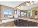 Bright bathroom boasts double vanity, soaking tub and mountain views from large window at 22268 E Hidden Trail Dr, Parker, CO 80138