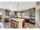 Open kitchen features stainless steel appliances, granite counters, hardwood floors, and eat-in island at 22268 E Hidden Trail Dr, Parker, CO 80138