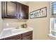 Laundry room features a utility sink and ample cabinet space for cleaning supplies and storage at 22268 E Hidden Trail Dr, Parker, CO 80138