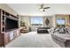 Spacious living room with large sectional sofa, entertainment center, ceiling fan, and natural light from a large window at 22268 E Hidden Trail Dr, Parker, CO 80138