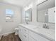 Bright bathroom featuring a double vanity, framed mirrors, and a window that lets in natural light at 4965 Collinsville Pl, Highlands Ranch, CO 80130