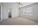 Bedroom with ceiling fan, carpet, view to bathroom and backyard view from window at 4965 Collinsville Pl, Highlands Ranch, CO 80130