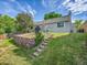 Well-maintained backyard featuring a stone retaining wall and stairs leading to the upper lawn at 5319 E Davies Dr, Centennial, CO 80122