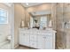 This bright bathroom has a double sink vanity, large mirror, and tiled shower with glass door at 3297 N Duquesne Way, Aurora, CO 80019